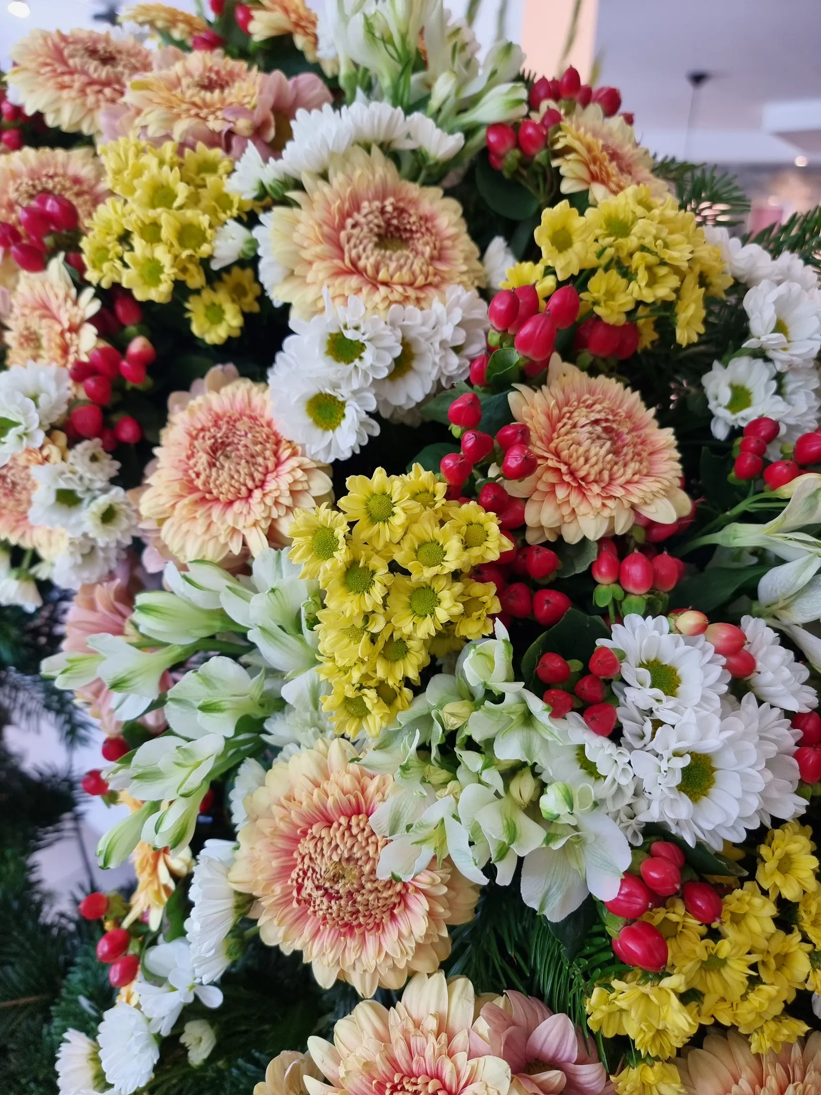 Buntes Gesteck aus Chrysanthemen und Hypericum