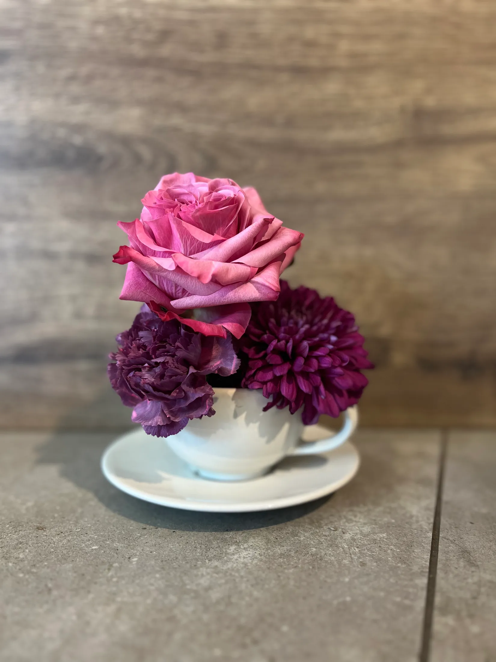 Rose und Dahlie in einer Tasse arrangiert