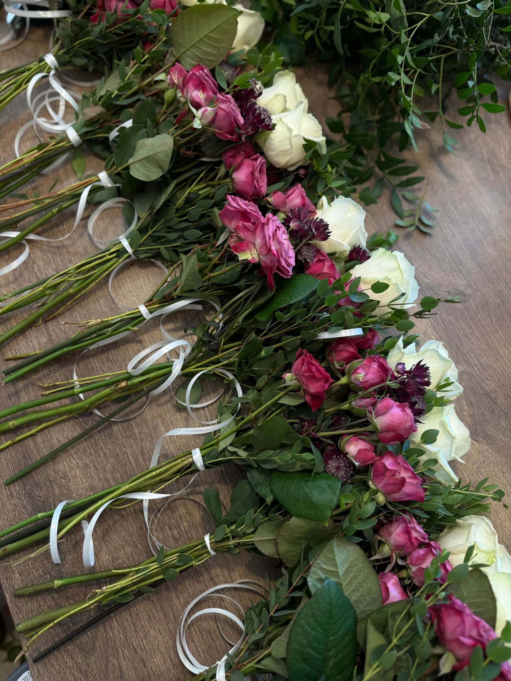 Vorbereitete Sträuße aus Rosen und Ranunkeln in der Werkstatt