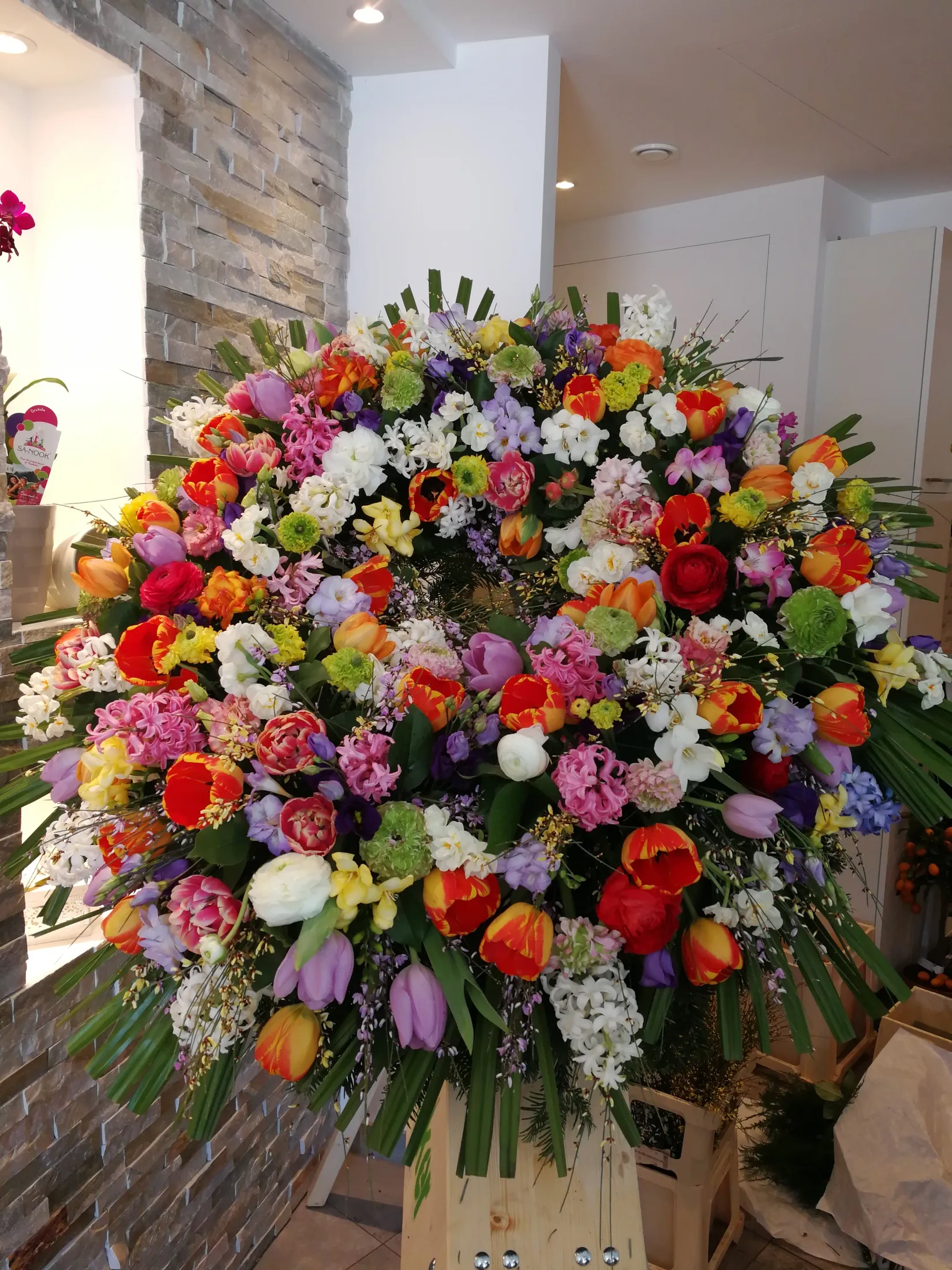 Farbenfrohes Trauergesteck mit Tulpen und Nelken