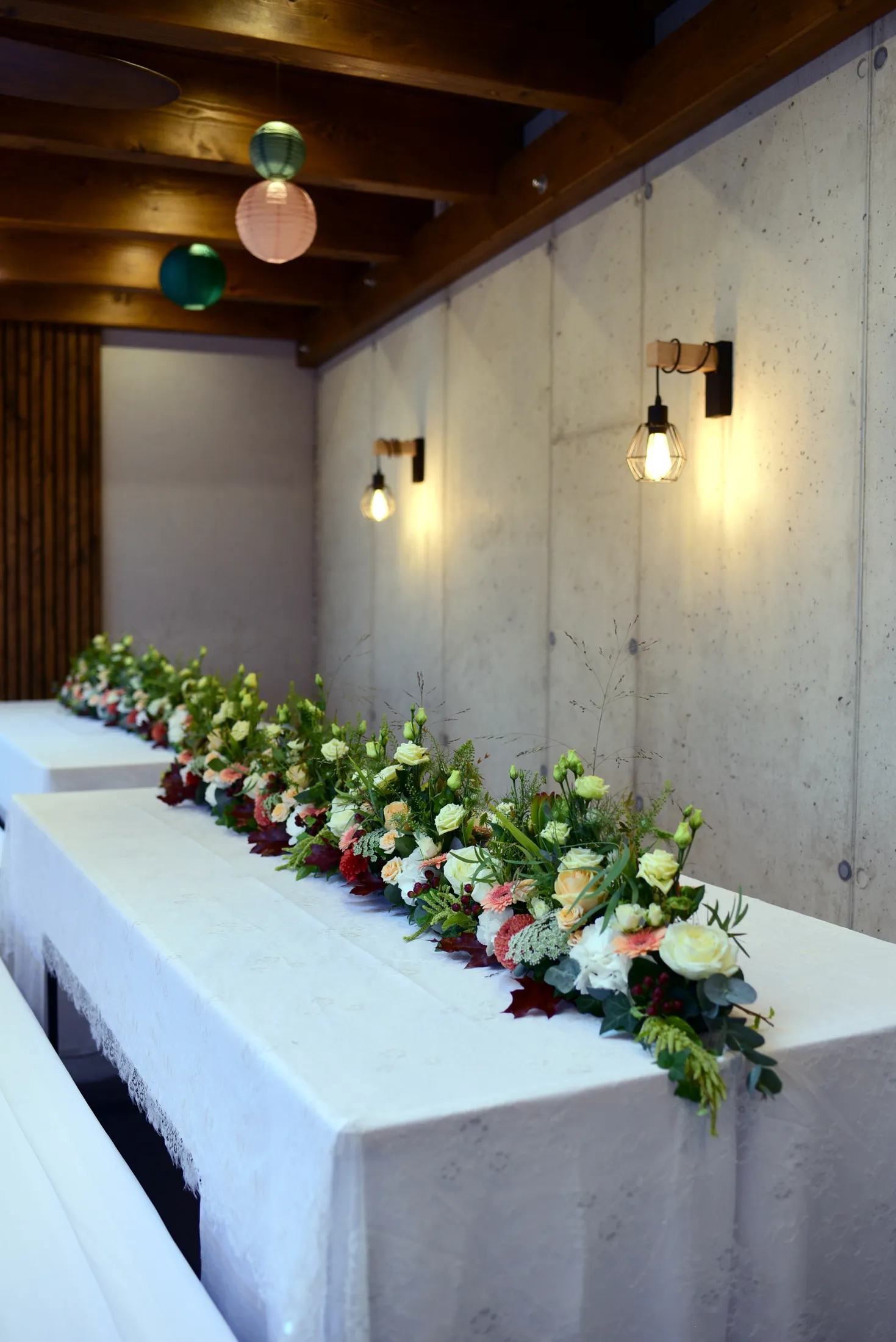 Lange Tafel mit durchgehendem Blumenschmuck in Weiß und Rot
